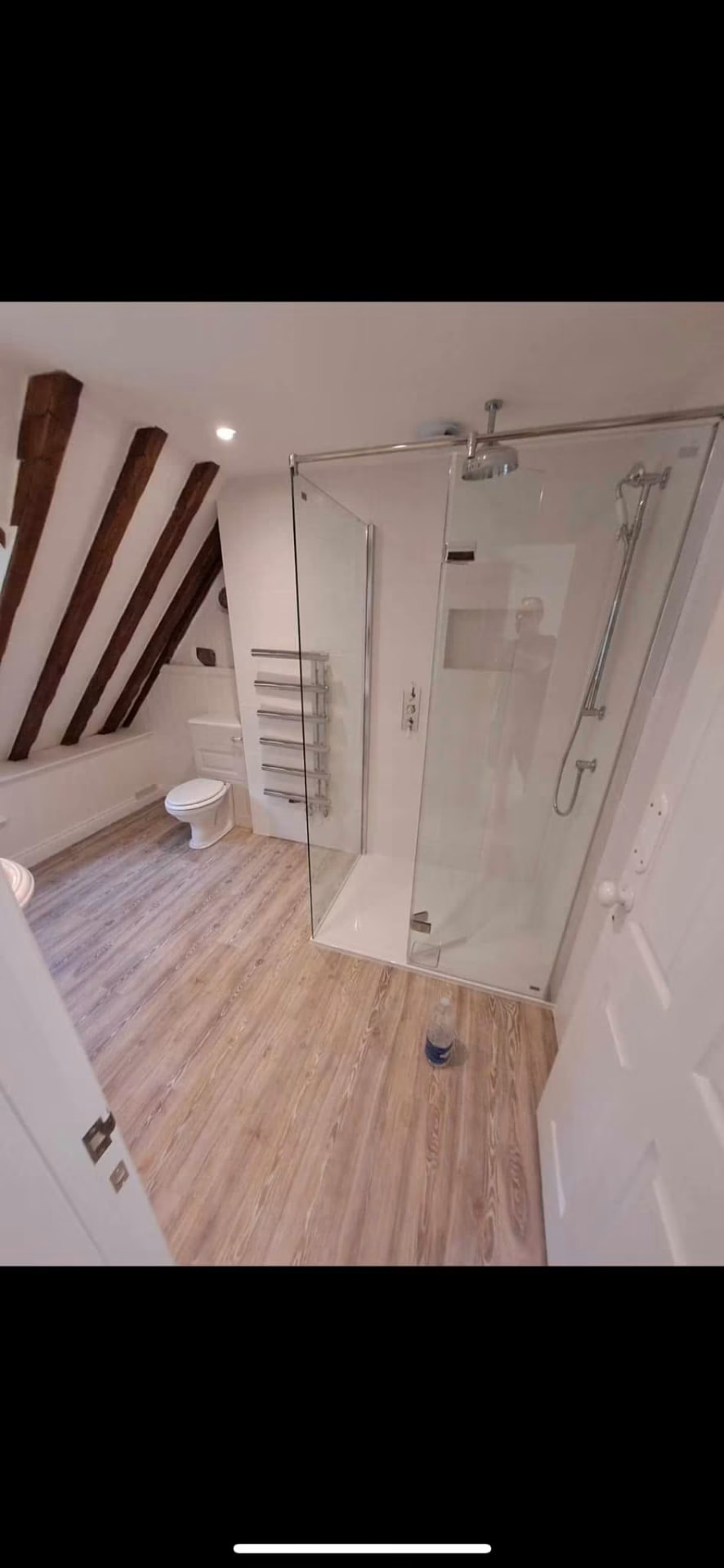 Finished ensuite with frameless glass shower, heated towel rail and exposed beams