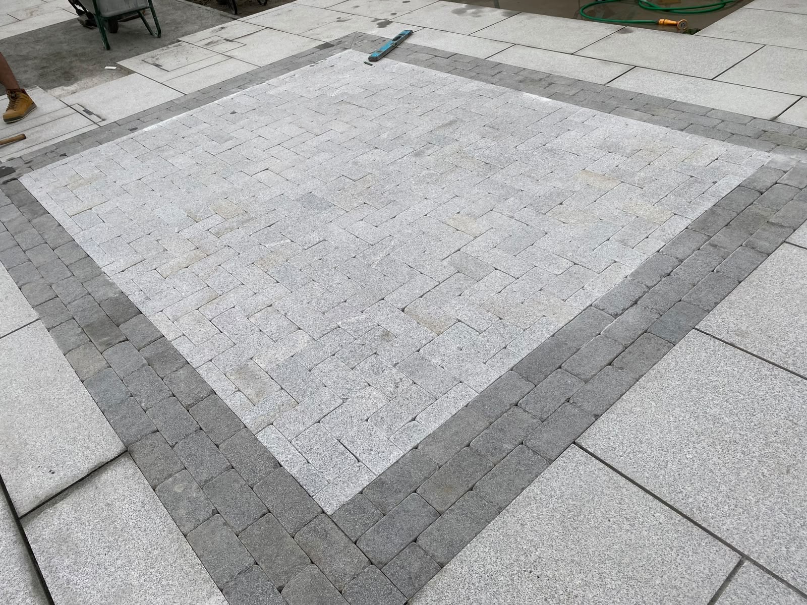 Finished feature inlay panel framed by dark granite sett borders