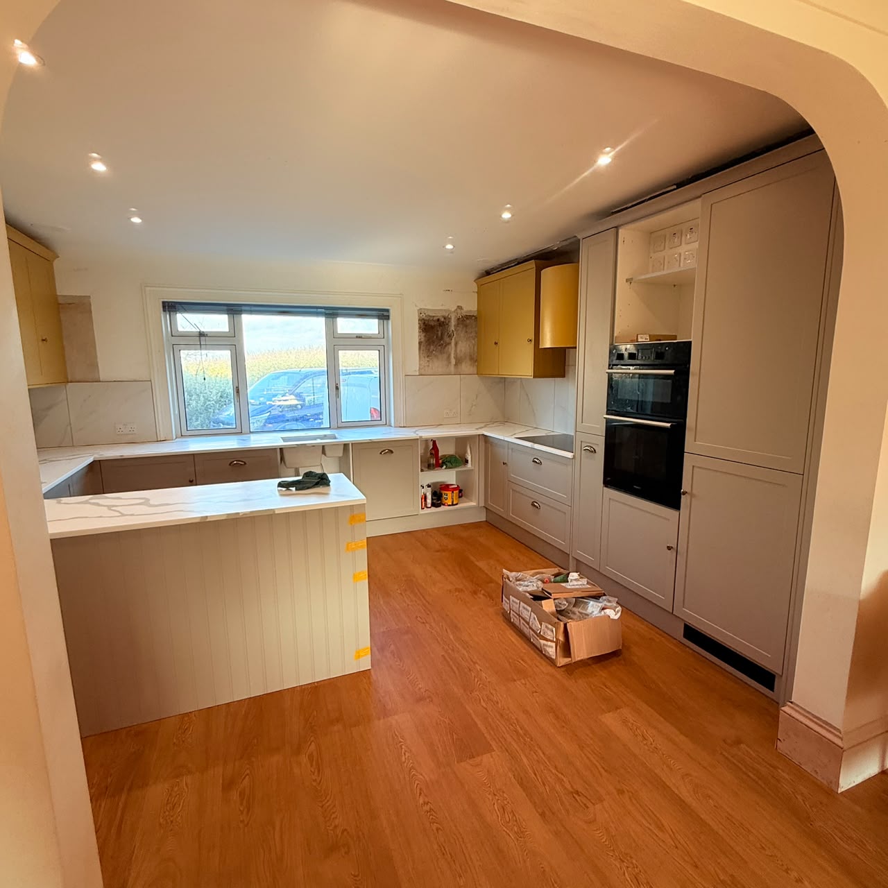 Freshly plastered arch opening linking the kitchen to the living space
