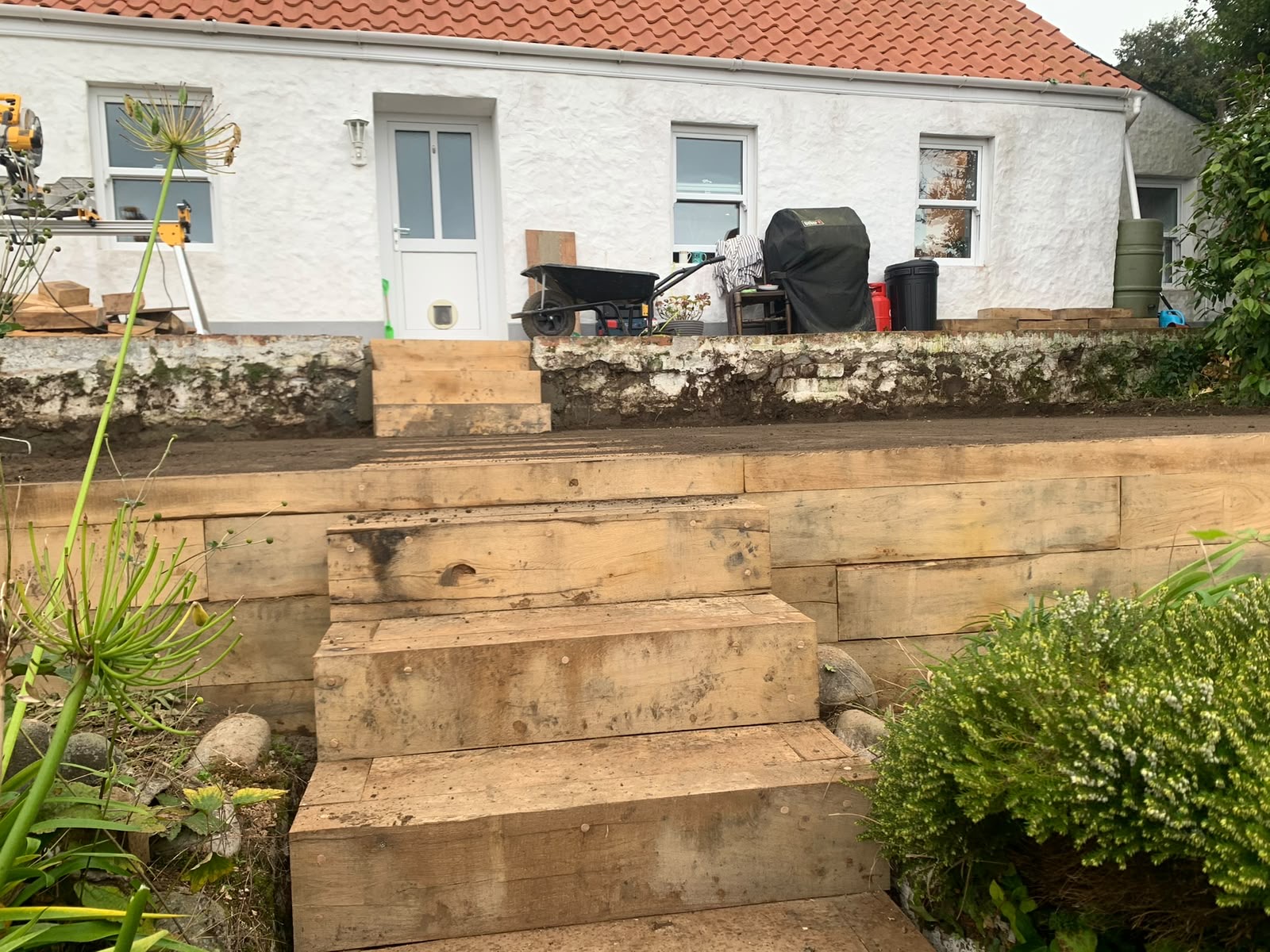 Solid sleeper steps rising from the garden to the house terrace