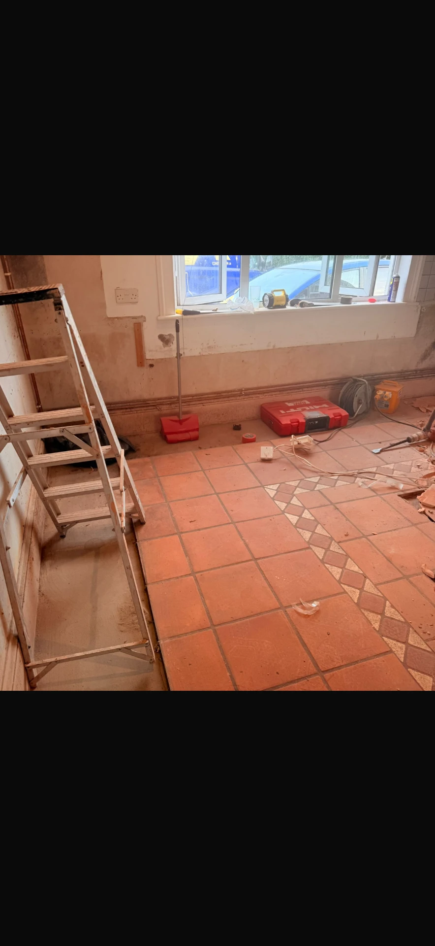 Kitchen stripped back — units, tiles and skirting boards removed