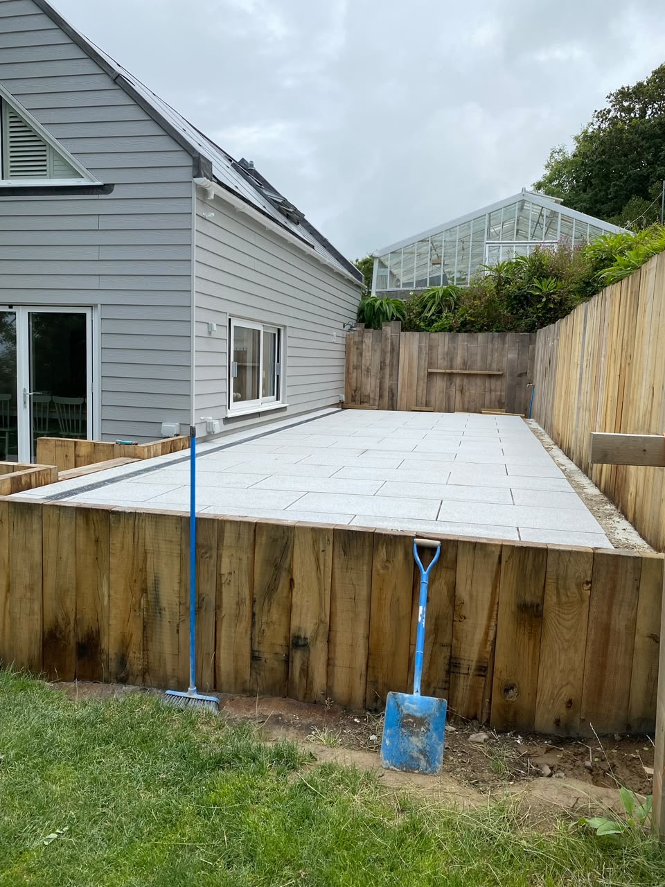 After — Completed terrace framed by oak sleeper retaining walls