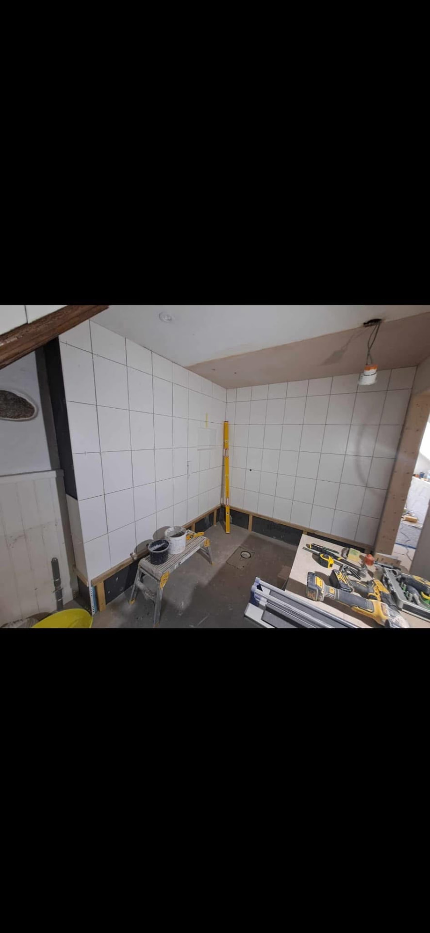 Full-height tiling completed and set out ready for the shower installation