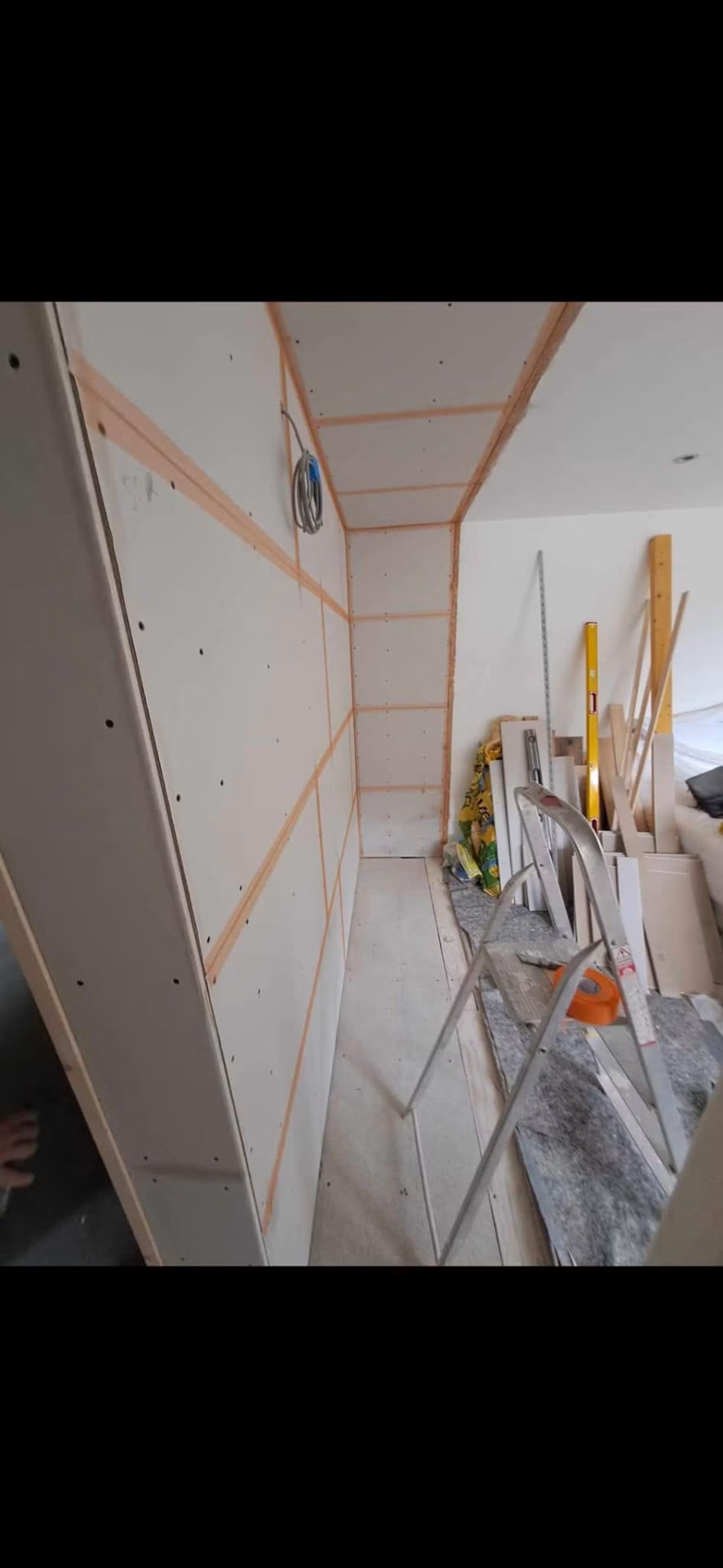 Fitted wardrobe recess plasterboarded and taped ready for skimming