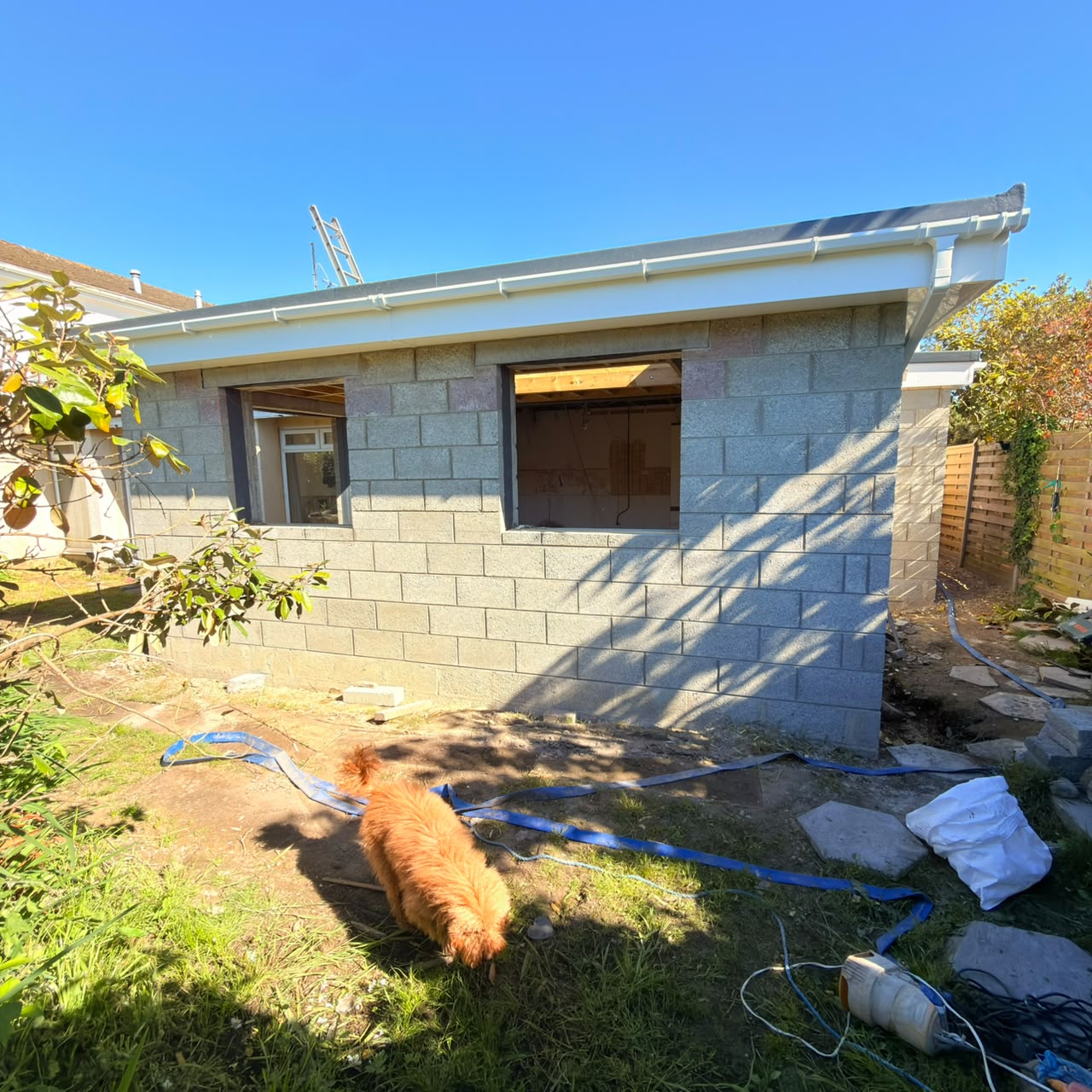 Completed structural extension shell with flat roof and guttering — Guernsey