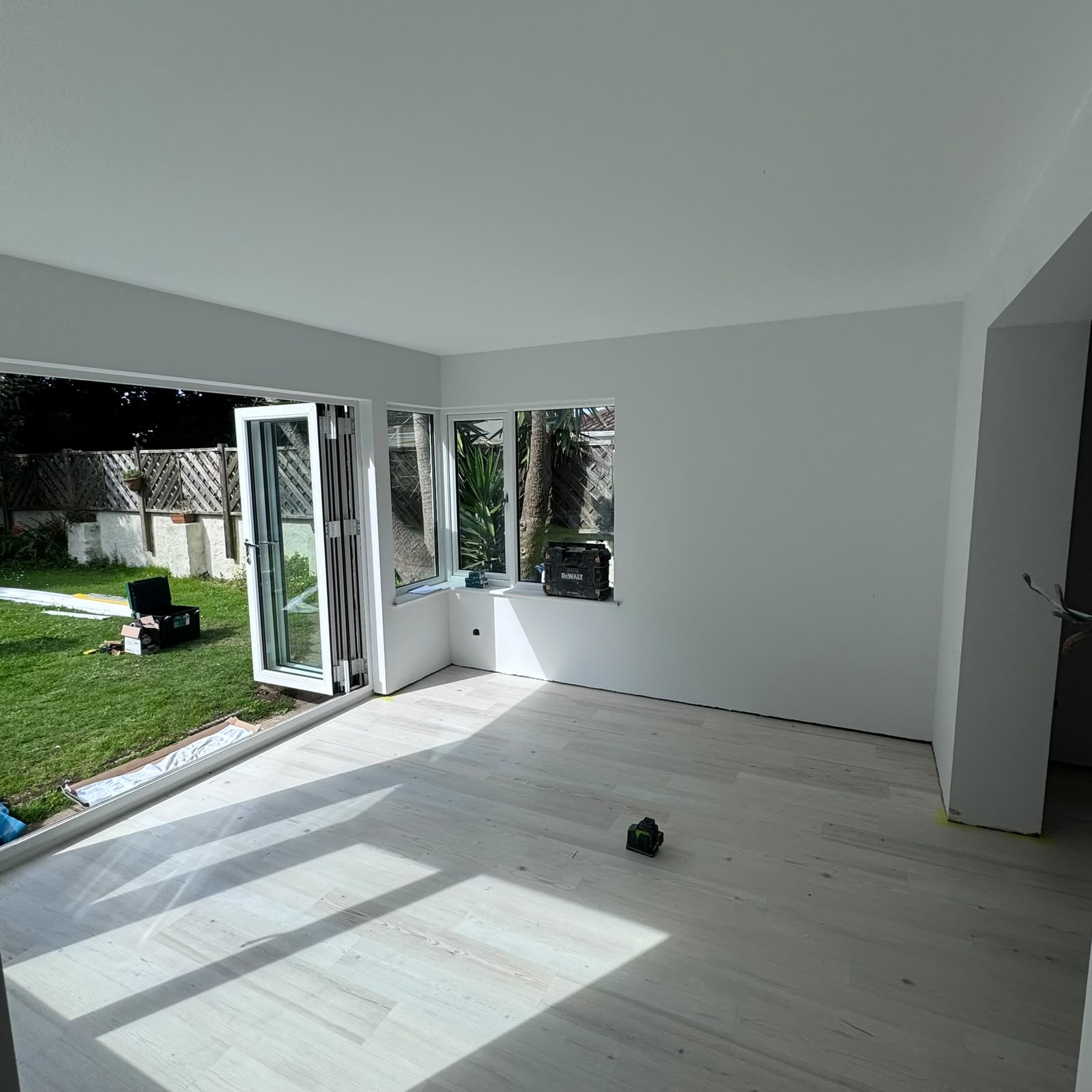 After — Corner glazing and bi-folds flooding the room with light