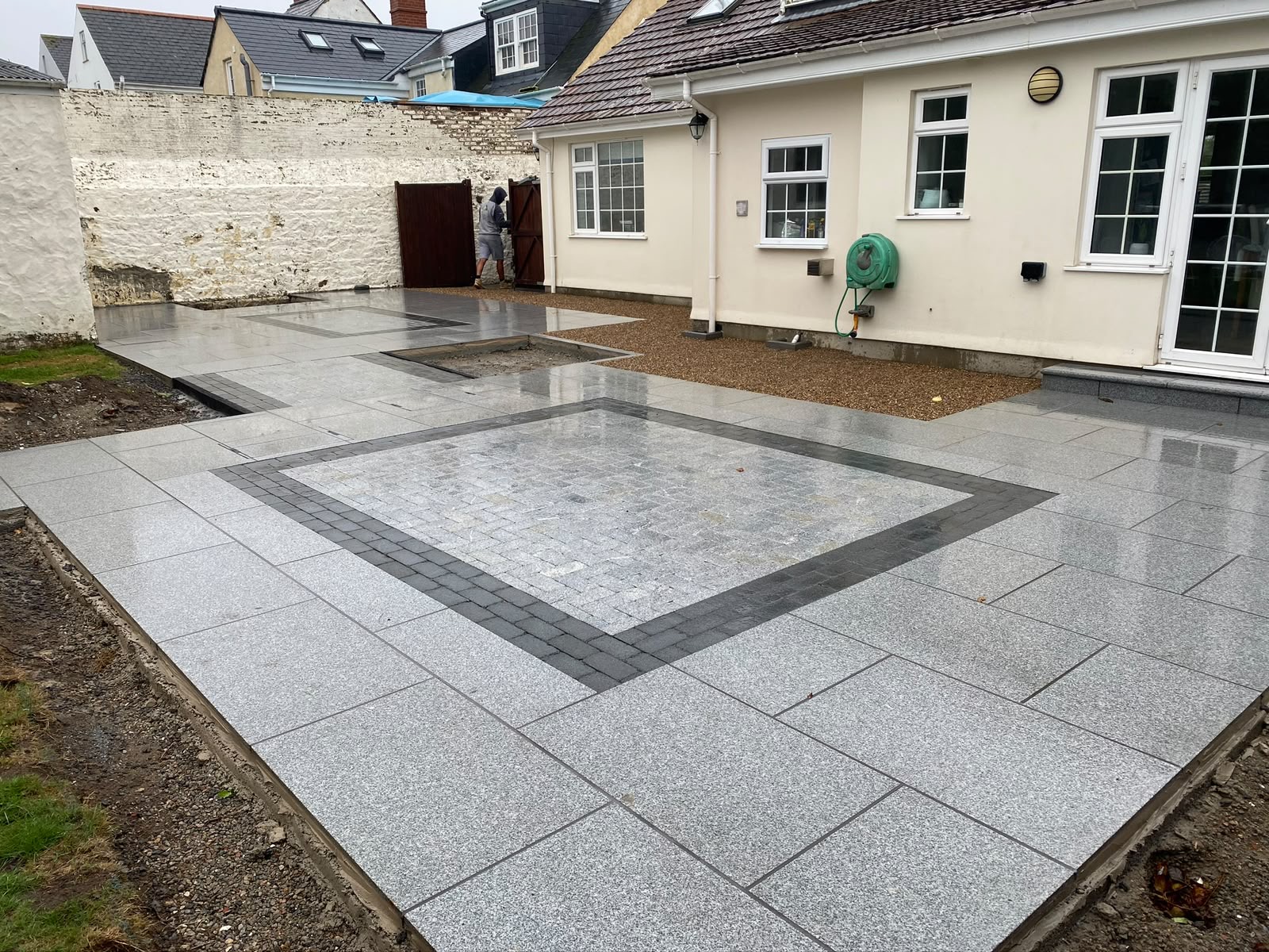 Completed bespoke grey granite patio with dark sett inlay border — Guernsey