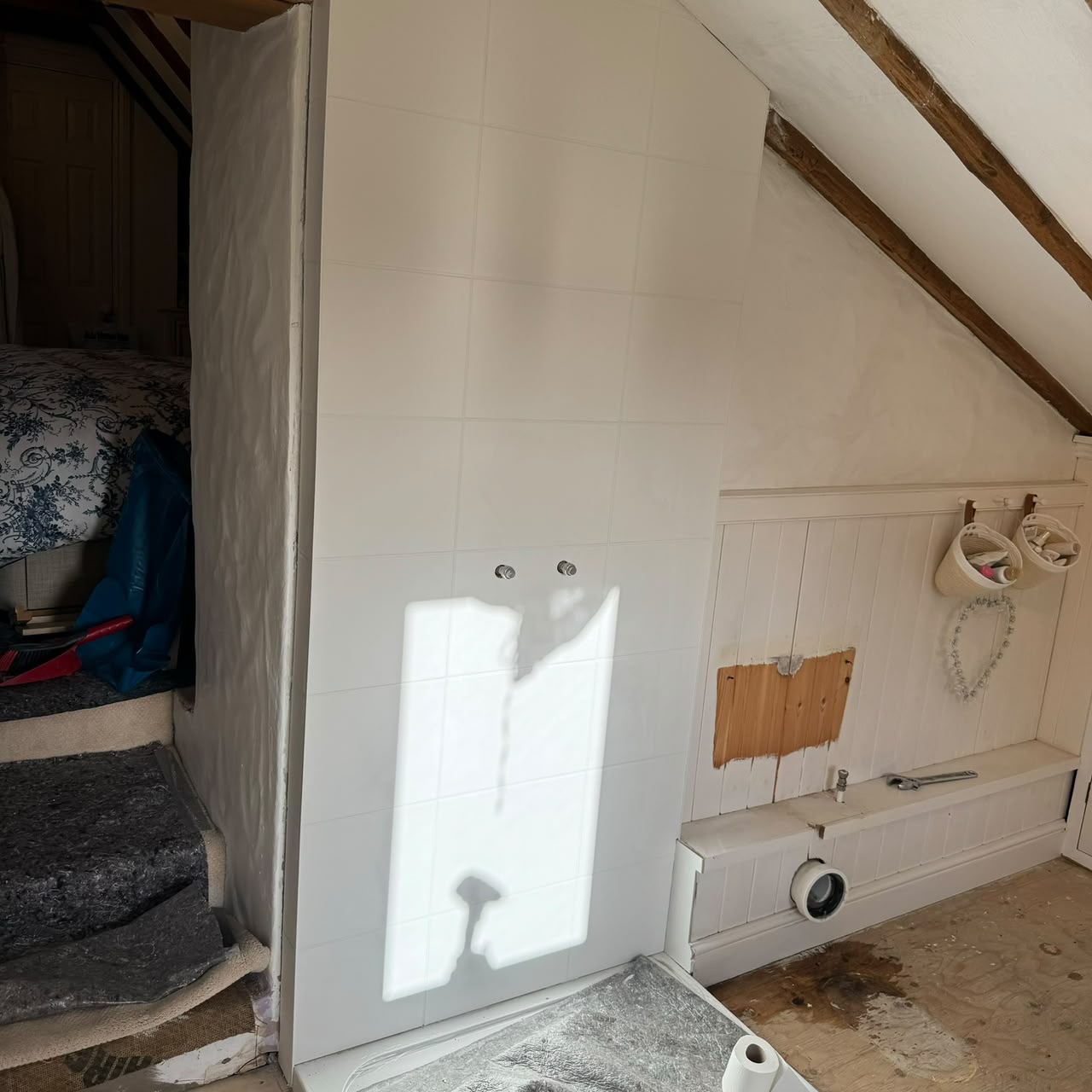 Existing tiling and panelling opened up to reroute services for the new layout