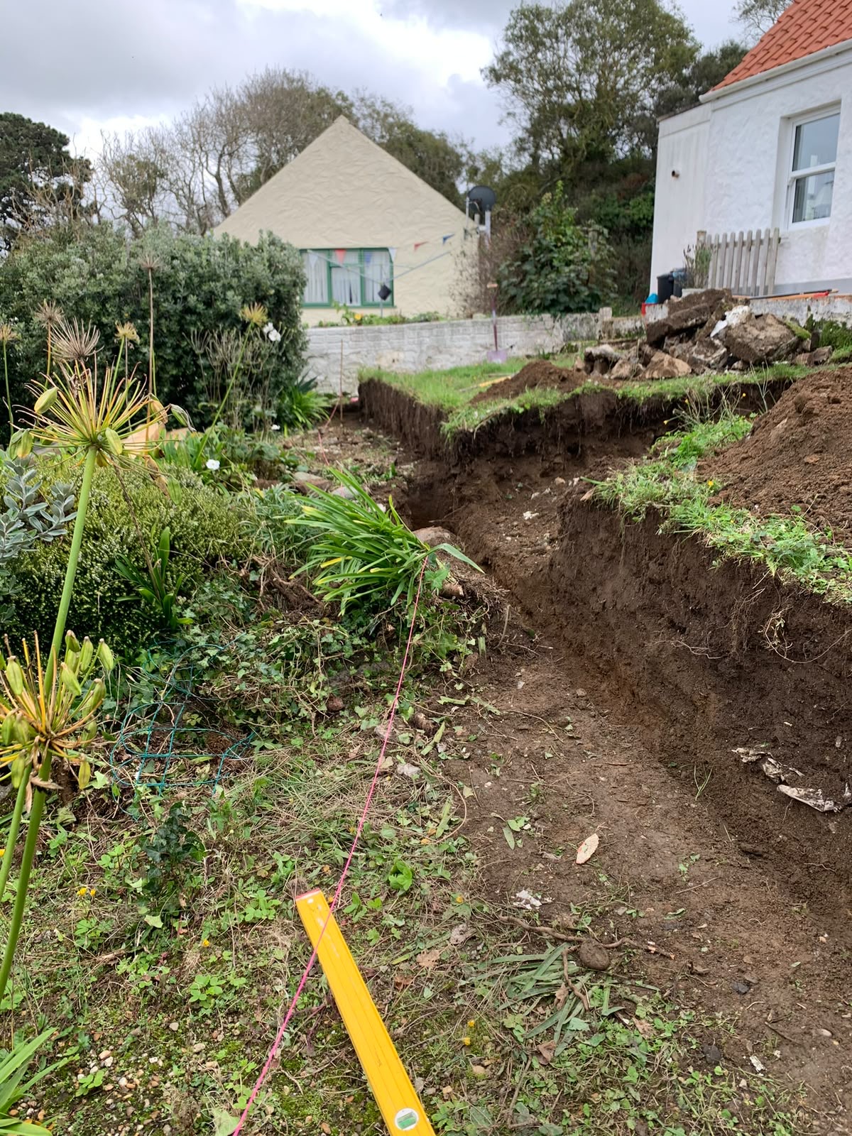 Deep foundation trench running the length of the new wall