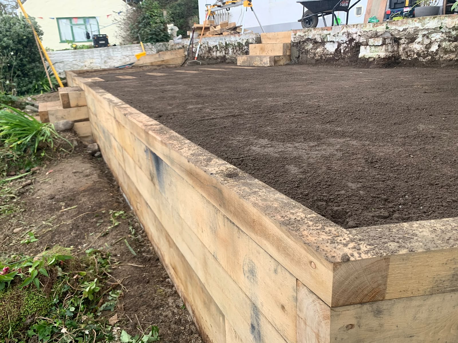 Raised sleeper bed backfilled and topsoiled ready for planting