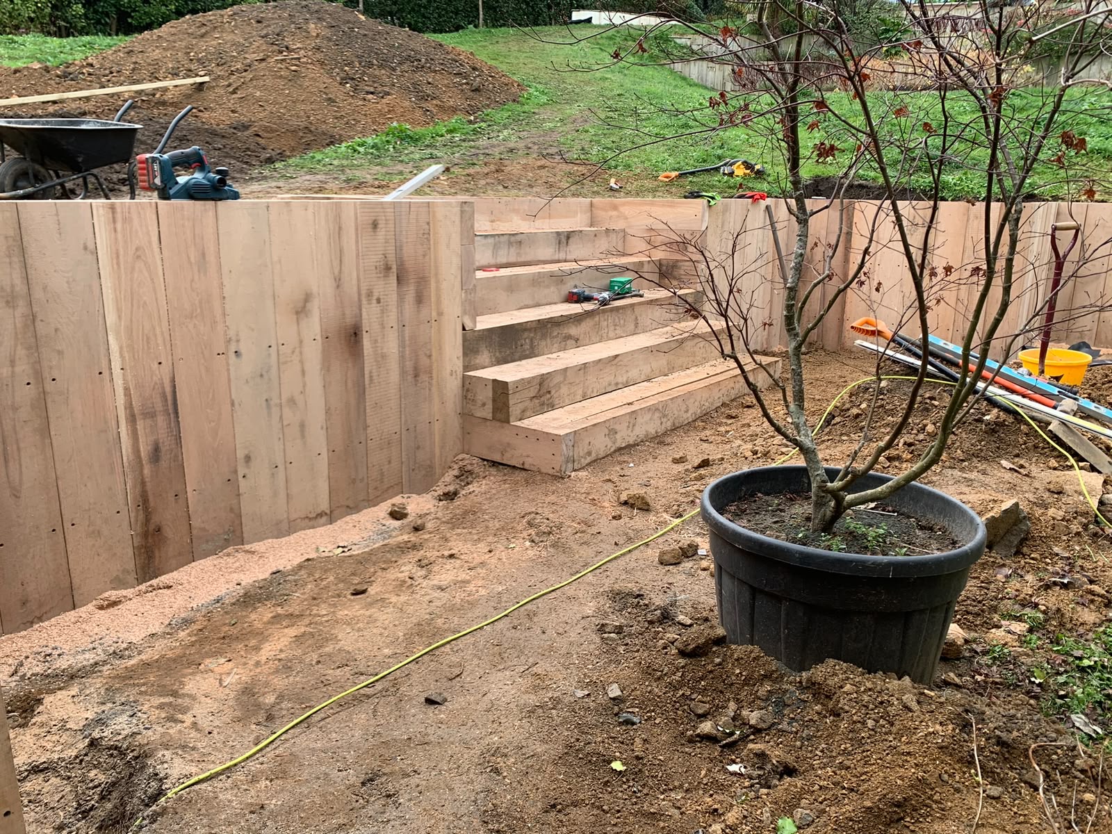 Oak sleeper steps and retaining walls built before backfilling