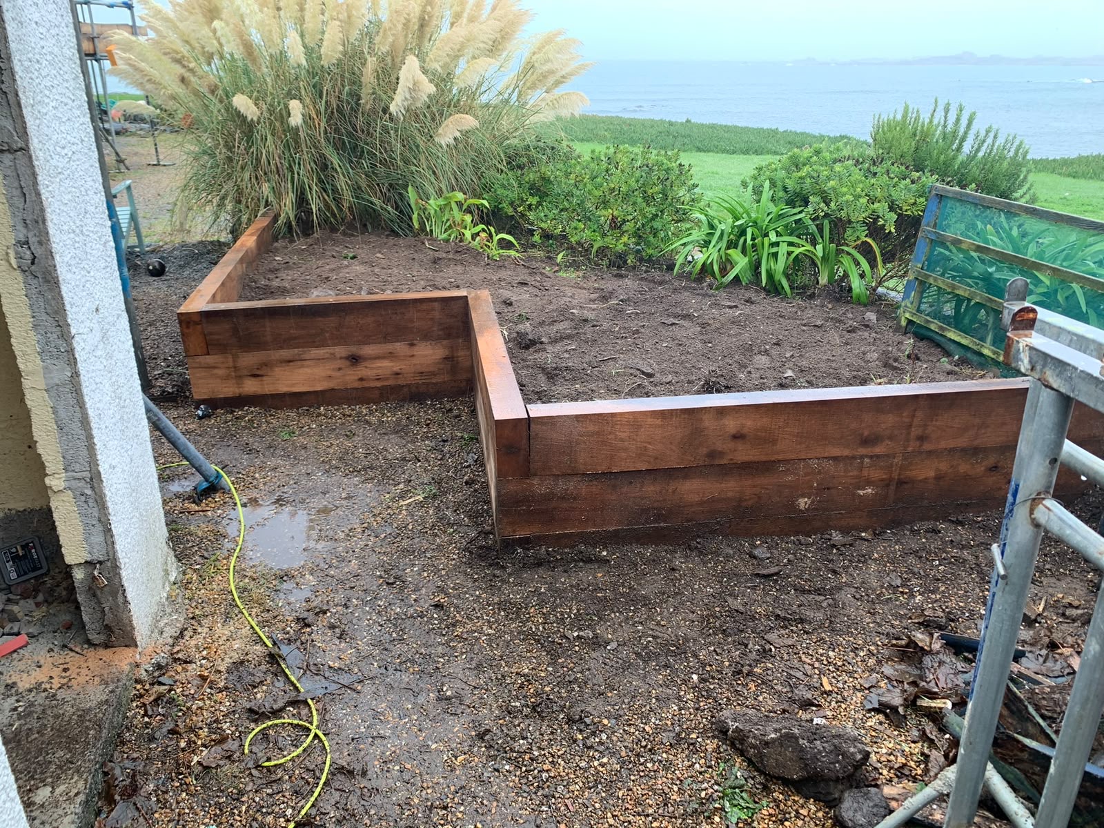 Finished sleeper planters framing the coastal garden