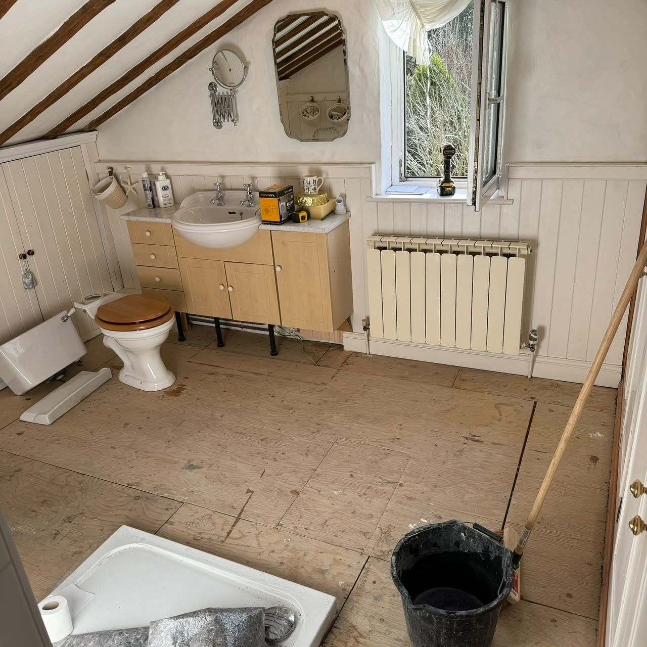 The original dated bathroom before works began, stripped back to bare boards