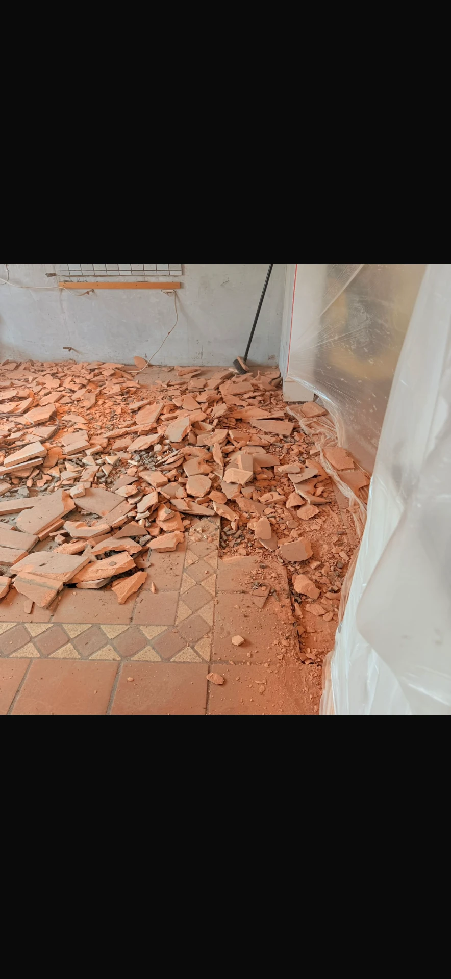 Floor tiles lifted and cleared behind dust protection screening